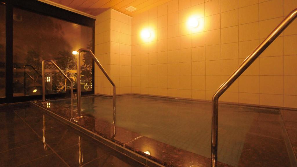 un bagno con doccia e lavandino. di AB Hotel Tahara a Tahara