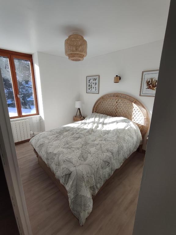 une chambre avec un lit dans une pièce avec une fenêtre dans l'établissement O fil de l'o, à La Bourboule