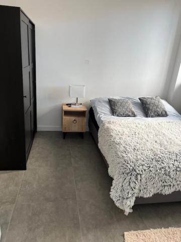 a bedroom with a bed and a night stand with a lamp at City Center Szczytno in Szczytno
