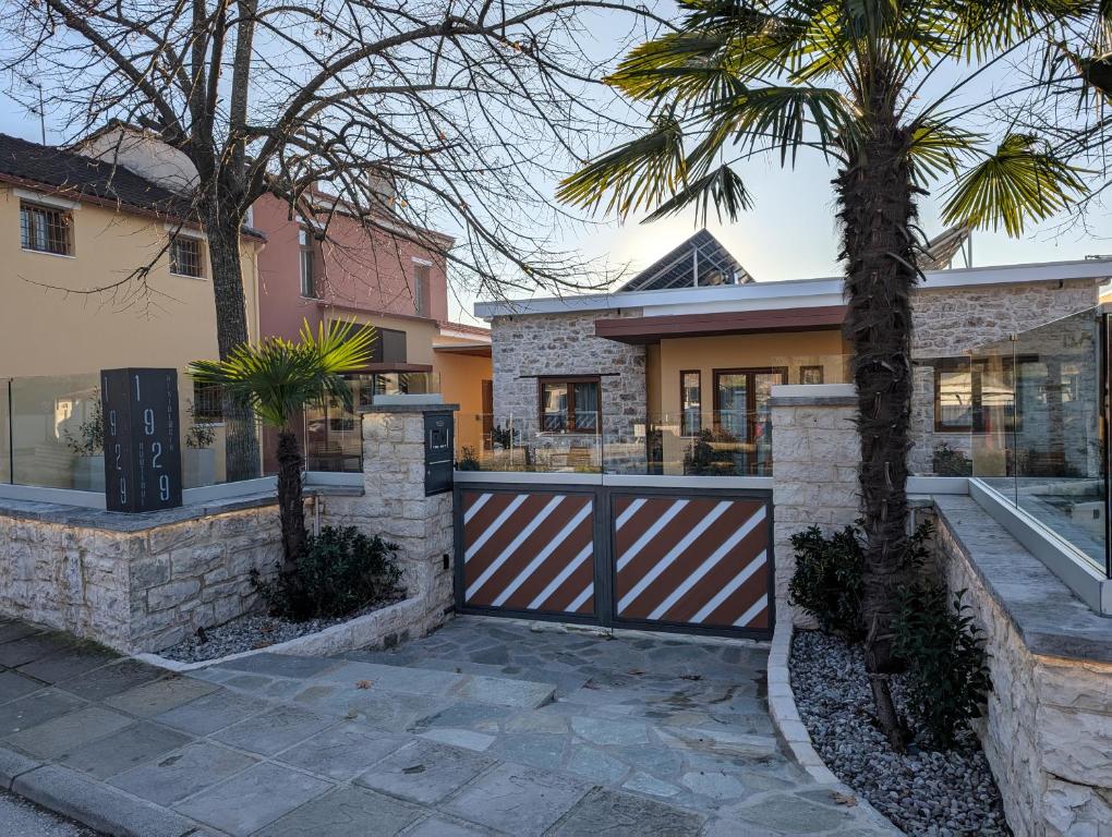 a house with a gate and a palm tree at 1929 Boutique Residences in Ioannina