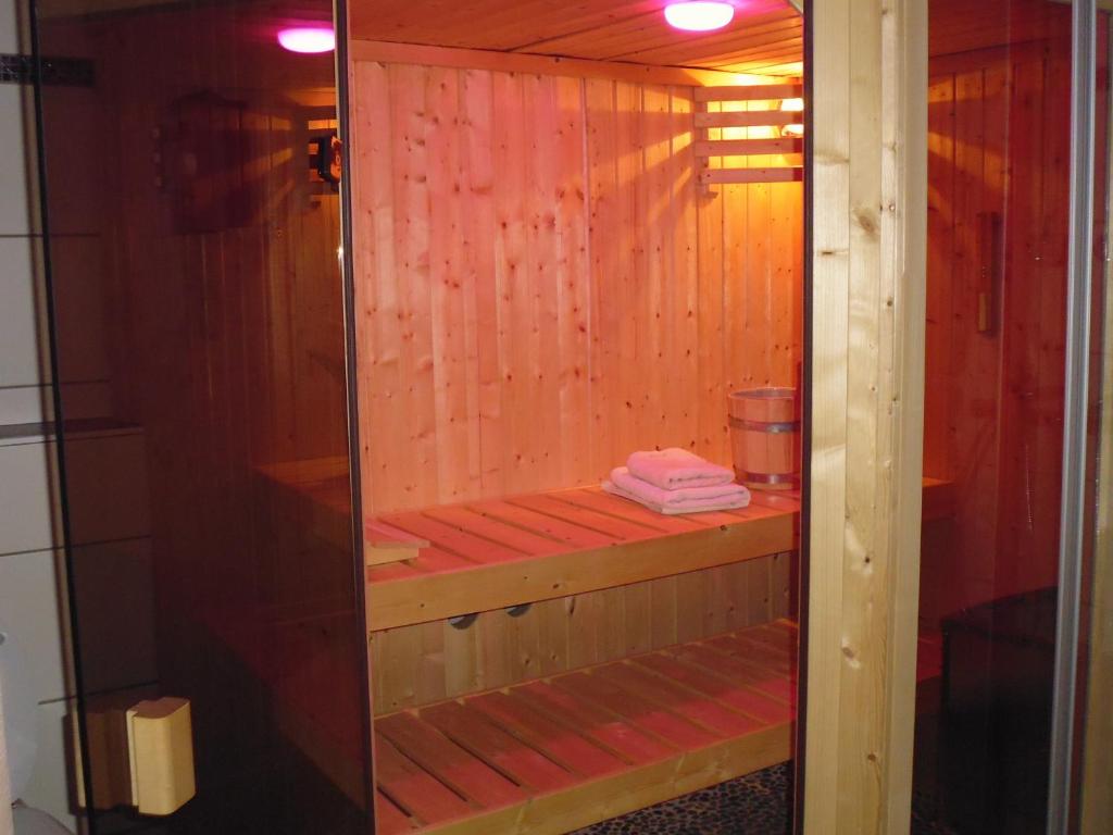 un sauna avec des murs en bois et une porte en verre dans l'établissement B&B V.K. PGmbH, à Saint-Vith