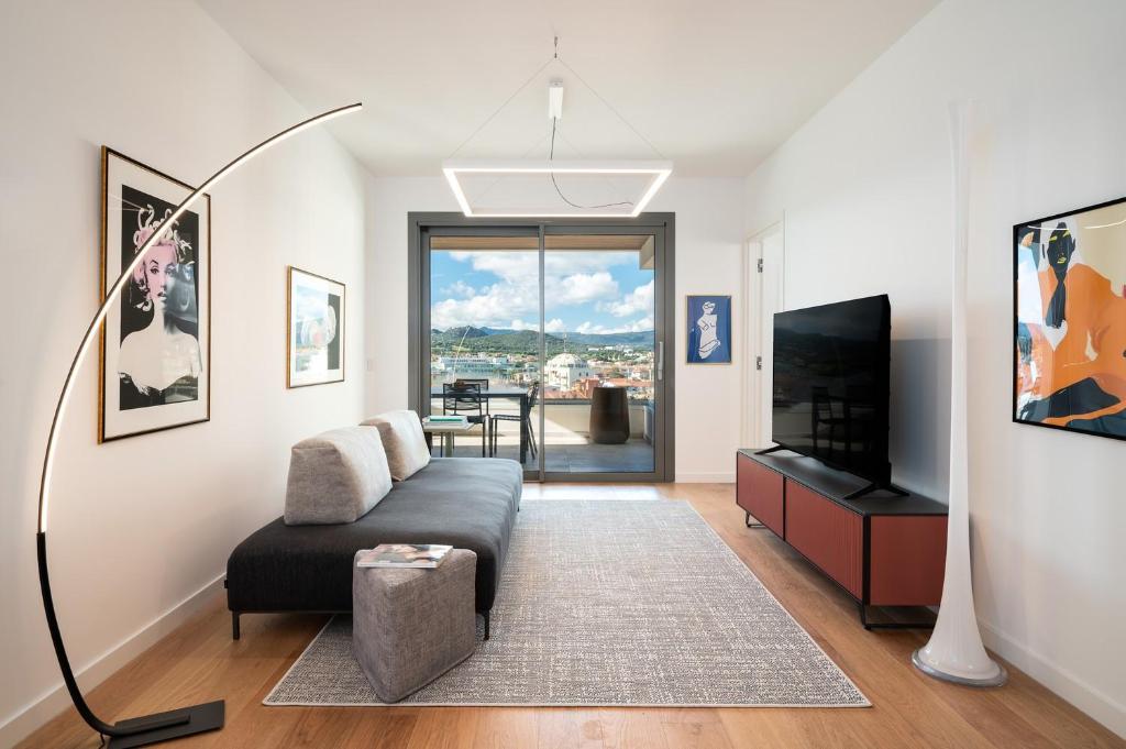 a living room with a couch and a flat screen tv at Alfiere Arc Loft by Klodge in Olbia
