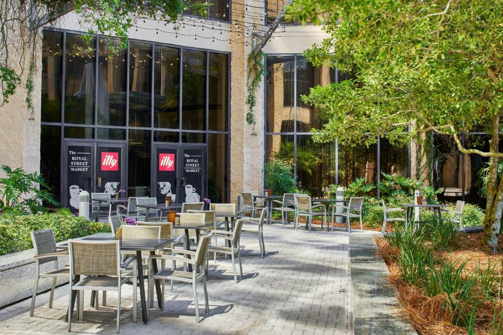 a group of tables and chairs in front of a building at Renaissance Mobile Riverview Plaza Hotel in Mobile