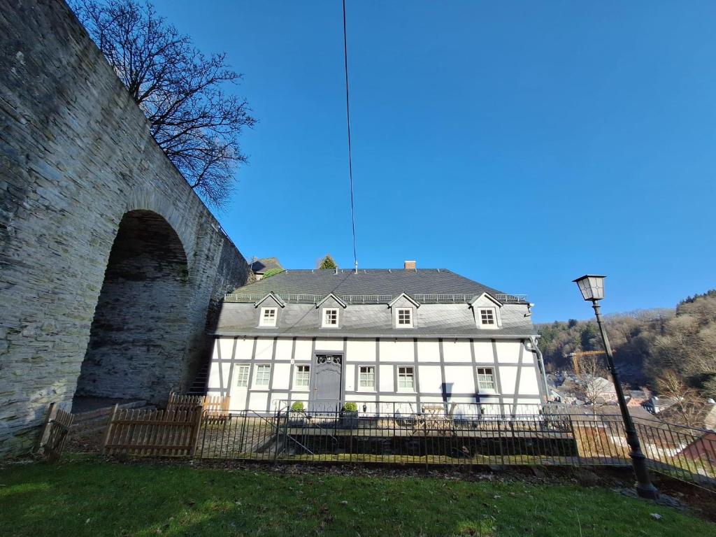a white house next to a stone bridge at Stachelburg in Monschau