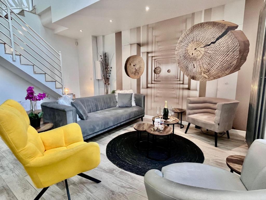 a living room with a couch and chairs at Duplex Design 6P - accès jardin et parking gratuit in Malakoff