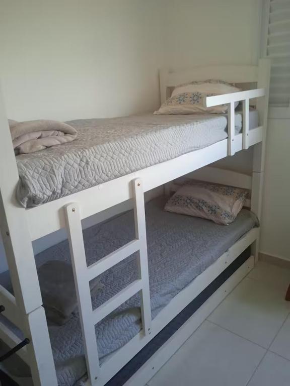 deux lits superposés dans une petite pièce avec dans l'établissement Estúdio Santa Faustina -Condomínio da Fé, à Cachoeira Paulista