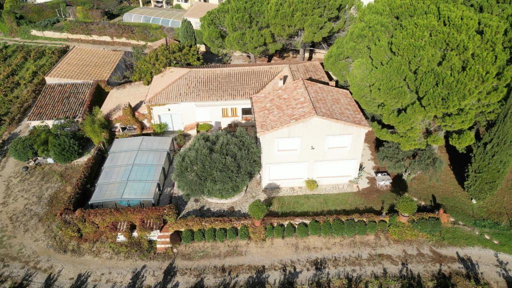 une vue aérienne sur une maison avec une serre dans l'établissement La Maison du Vigneron, à Montpeyroux