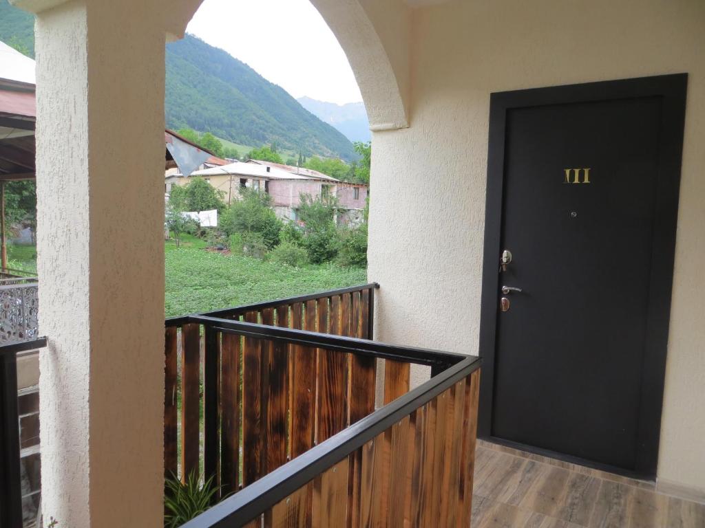 a black door on a balcony with a view at Guesthouse Bacha Lia in Mestia
