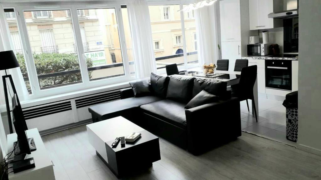 un salon avec un canapé et une table dans l'établissement Modern 1 bed flat - Near Arc de Triomphe & Champs Elysees, à Paris