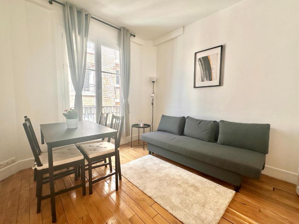 un salon avec un canapé et une table dans l'établissement Spacious flat near Montparnasse Bausset 4th, à Paris