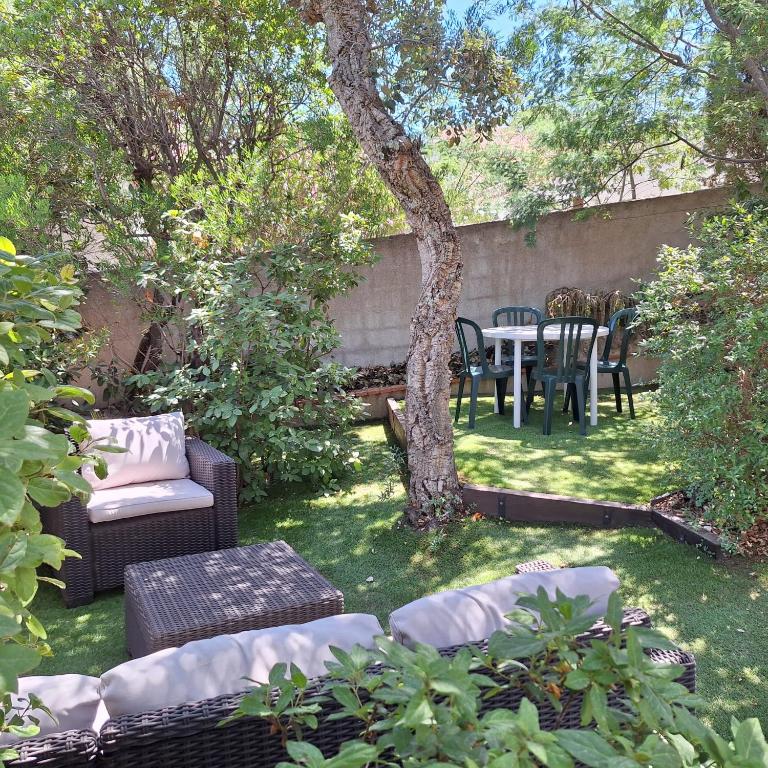 une cour avec une table, des chaises et un arbre dans l'établissement Calme et verdure près de la mer, à Fréjus