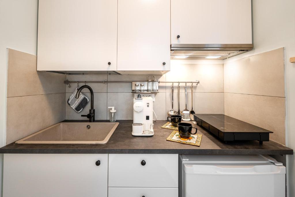 a kitchen with white cabinets and a sink at Suite Room Suriani in Rome