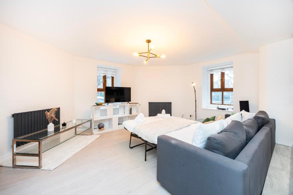 a living room with a couch and a tv at Modern 1 BR Apartment North London in London
