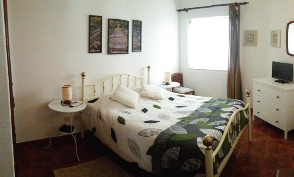 1 dormitorio con cama, mesa y TV en Casa Mar, en Tavira