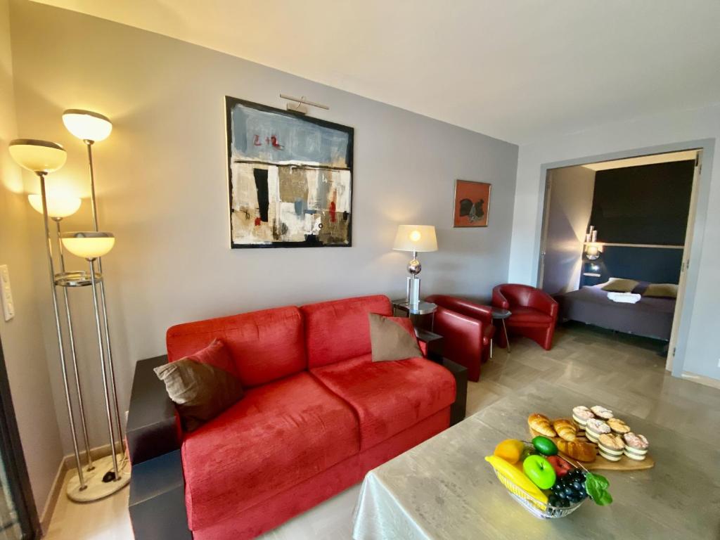 un salon avec un canapé rouge et une table dans l'établissement Résidence Gray d'Albion 2P 5402, à Cannes
