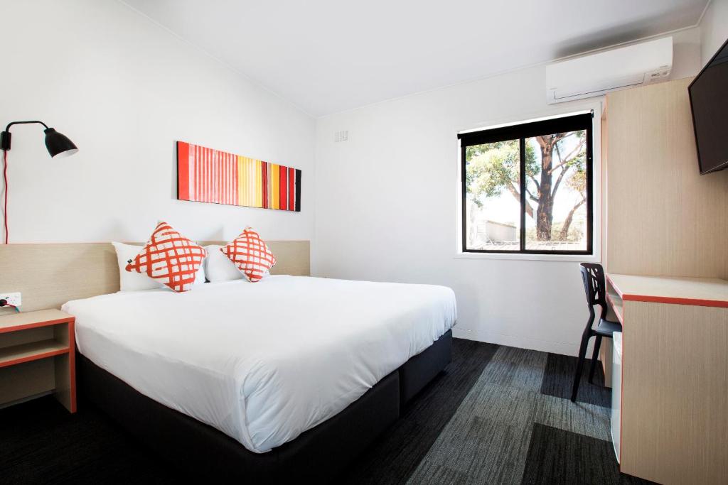 a hotel room with a large bed and a window at Villawood Hotel in Villawood