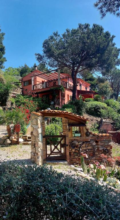 a house on top of a hill with a building at two-room apartment with parking space in Rio nellʼElba