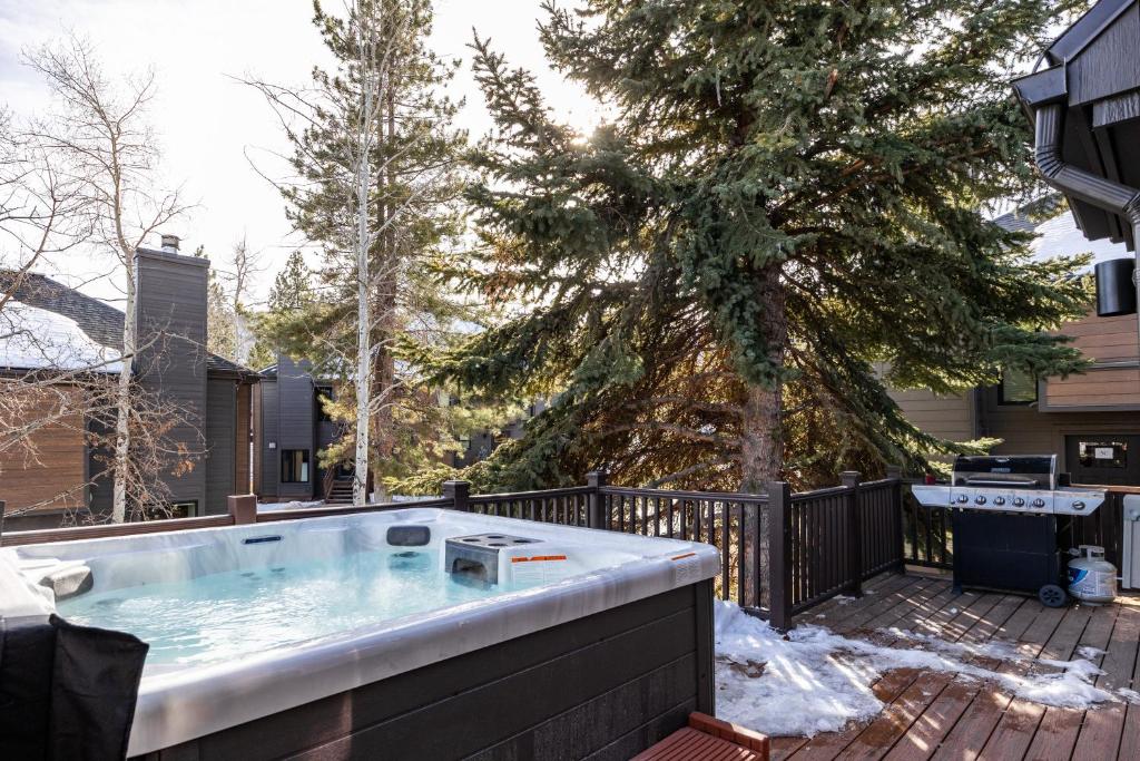 a hot tub on a deck next to a tree at Hidden Creek Canyons Retreat, Alpine Charm, Private Hot Tub, Sleeps 8, Cozy Fireplace, in Park City