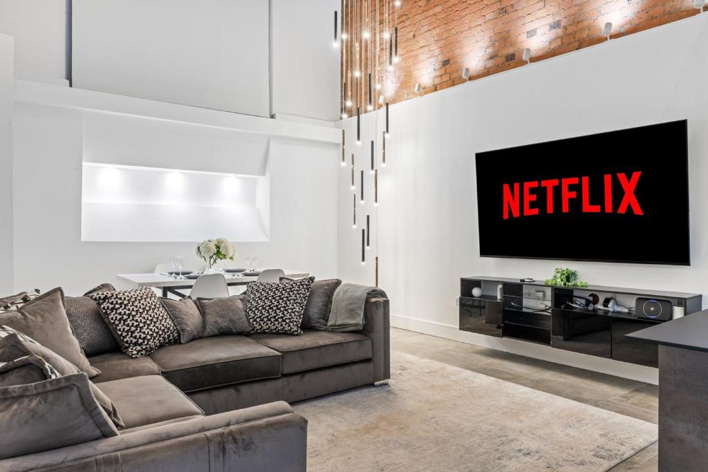 ein Wohnzimmer mit Sofa und Fernseher in der Unterkunft Luxury 2-Bed Apartment with Parking & Terrace in Nottingham