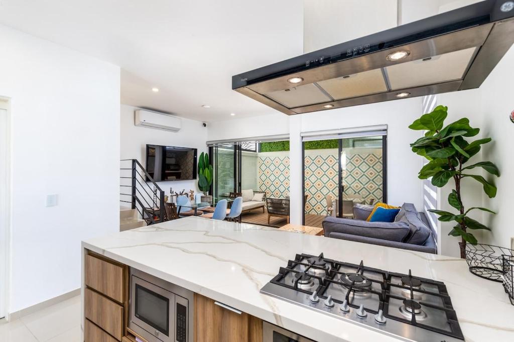 a kitchen with a stove and a living room at Ebano Residential in Las Juntas