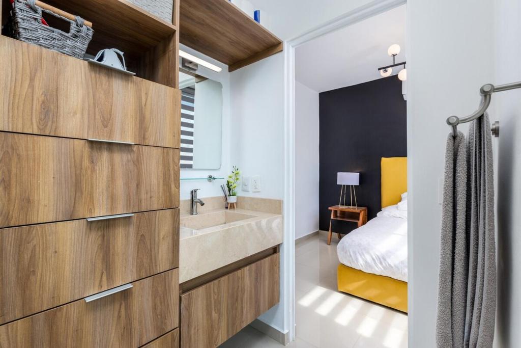 a bathroom with a large sink and a bed at Ebano Residential in Las Juntas