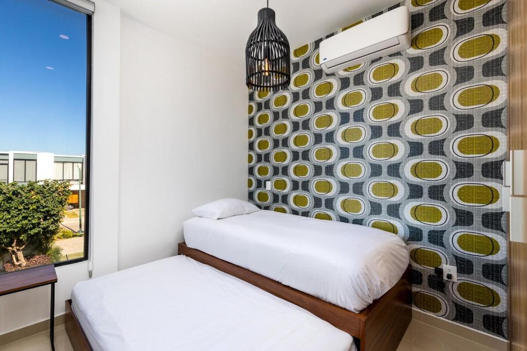 a small bedroom with two beds and a window at Ebano Residential in Las Juntas