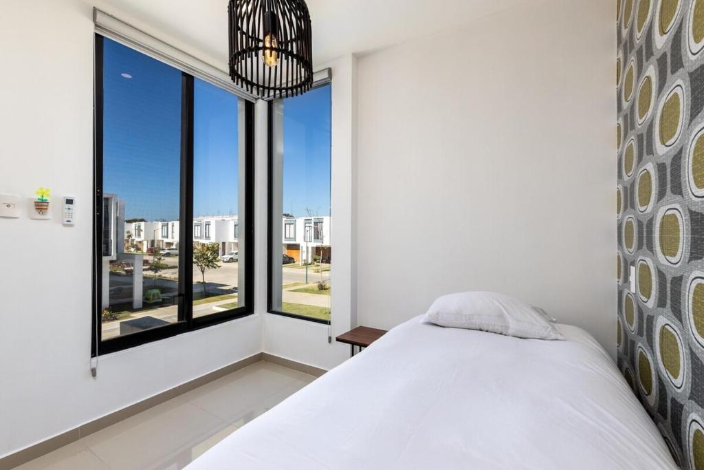 a bedroom with a bed and a large window at Ebano Residential in Las Juntas