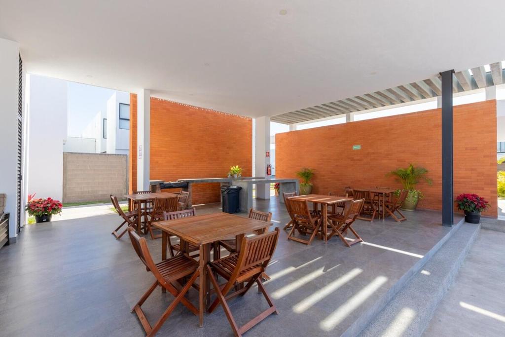 an outdoor patio with wooden tables and chairs at Ebano Residential in Las Juntas