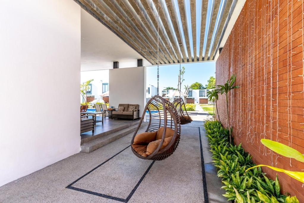 a porch with a hammock and a brick wall at Ebano Residential in Las Juntas