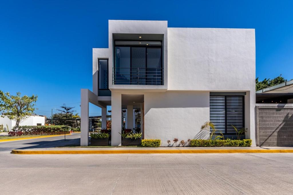a large white house on a street at Ebano Residential in Las Juntas