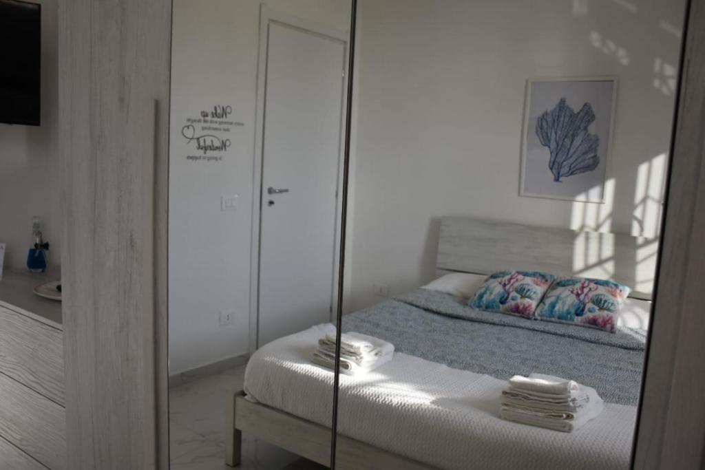 a bedroom with a mirror and a bed in a room at Casa Gimaga in Pozzuoli