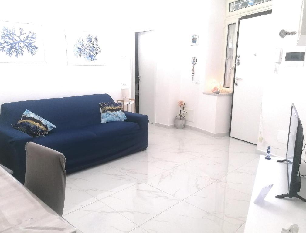 a blue couch in a living room with a tile floor at Casa Gimaga in Pozzuoli