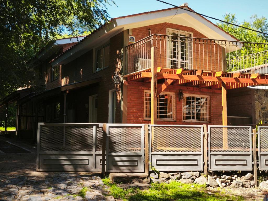 a house with a fence in front of it at Sonidos del Rio Aparts in Santa Rosa de Calamuchita