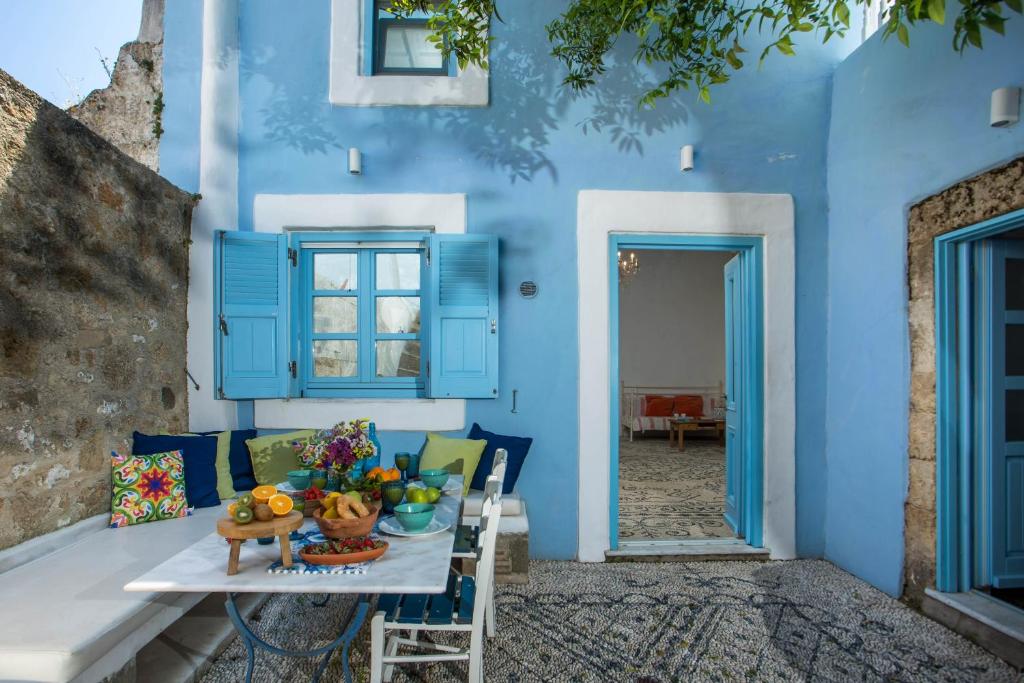 une maison bleue avec une table et un bol de fruits dans l'établissement Mandarin Greek Traditional Home, à Rhodes