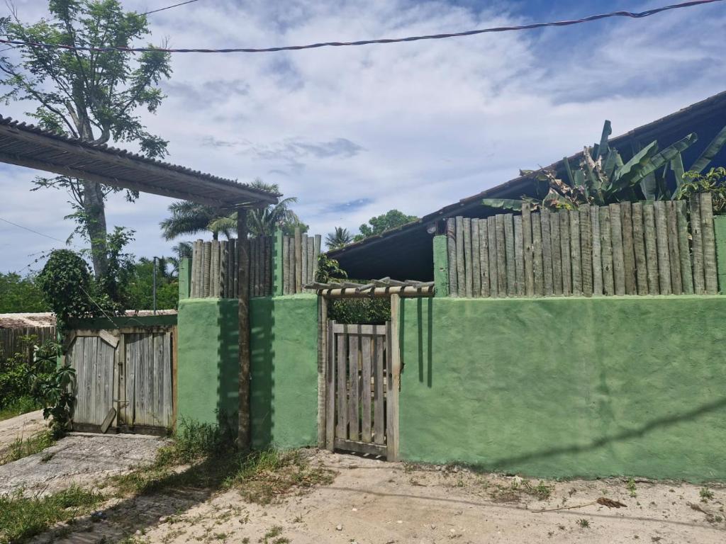 a wooden fence with a gate in front of a house at Casa da Briana in Trancoso