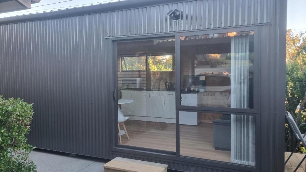 ein grauer Schiffscontainer mit einer Glasschiebetür in der Unterkunft Mangawhai studio in Mangawhai