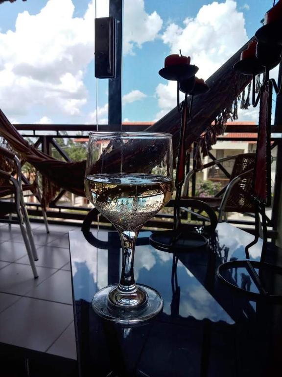 a glass of wine sitting on a table at Flat Monte Castelo em Gravata PE in Gravatá