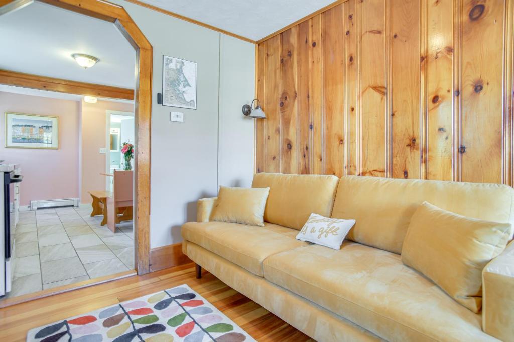 a brown couch in a living room with wooden walls at Walk to Grays Beach Park Kingston Seaside Escape in Kingston