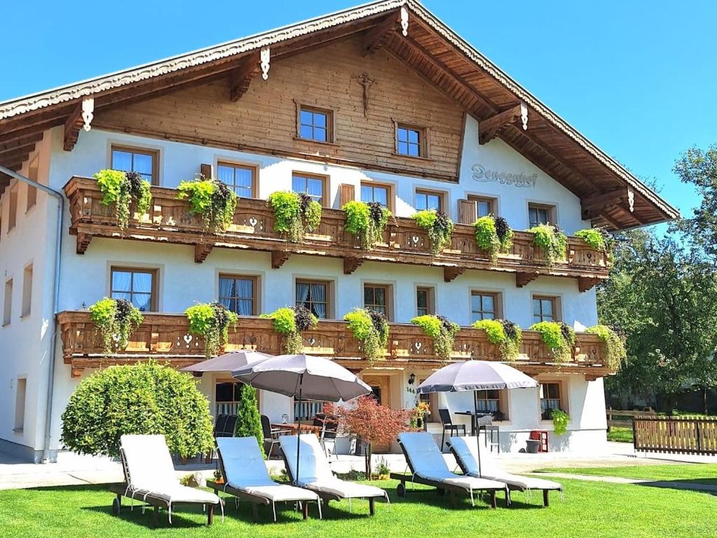 un hotel con sillas y sombrillas delante en Denggnhof, en Münster
