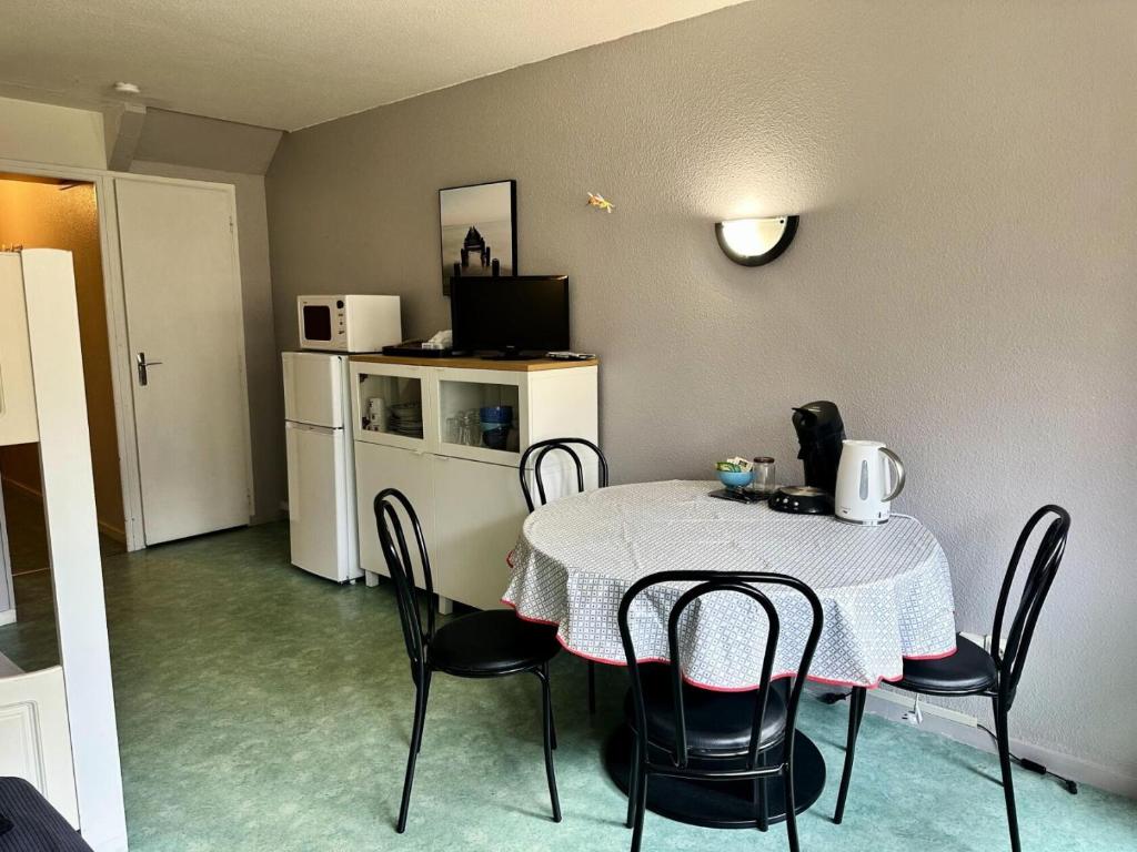 une salle à manger avec une table et des chaises et une cuisine dans l'établissement Résidence Le Tourmalet - maeva Home - Studio 4 personnes - Confort MAE-8071, à La Mongie