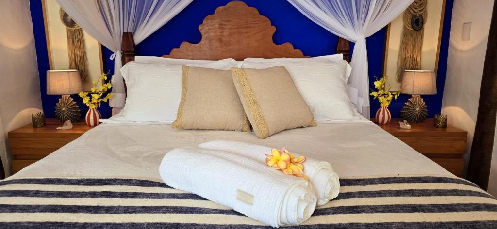 a bedroom with a bed with towels on it at Suíte Kuta - Buddha House in Ilhabela