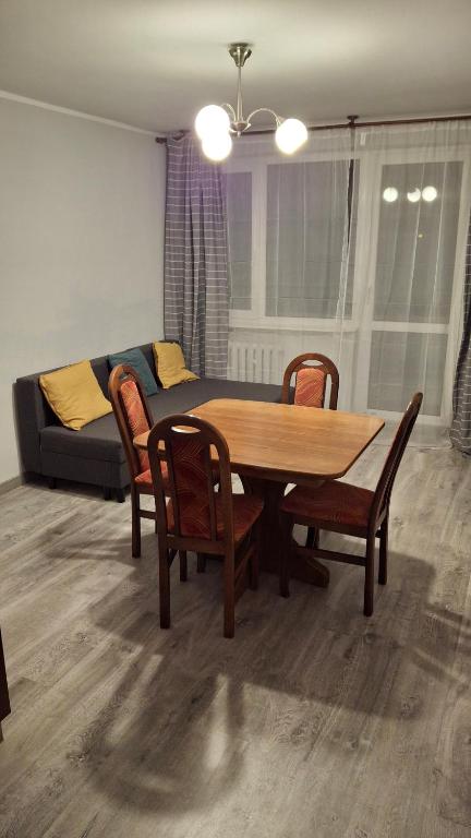 a living room with a table and chairs and a couch at Mieszkanie 2-pokojowe 40 m2 blisko centrum in Starogard Gdański