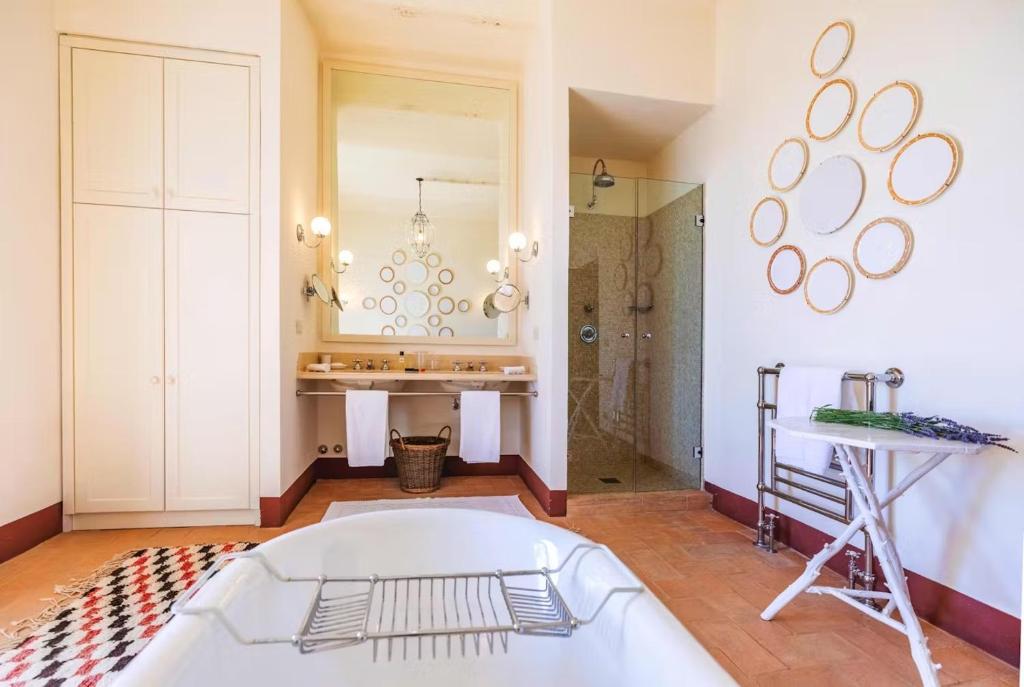 Un baño con bañera, lavabo y espejo. en Villa Melissa, en Fighine