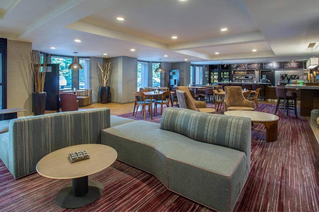 a living room with couches and tables and a bar at Courtyard Knoxville Cedar Bluff in Knoxville