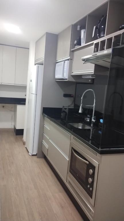 a kitchen with a sink and a stove top oven at Apartamento completo B51,com ar condicionado,400 m do centro in Mogi das Cruzes