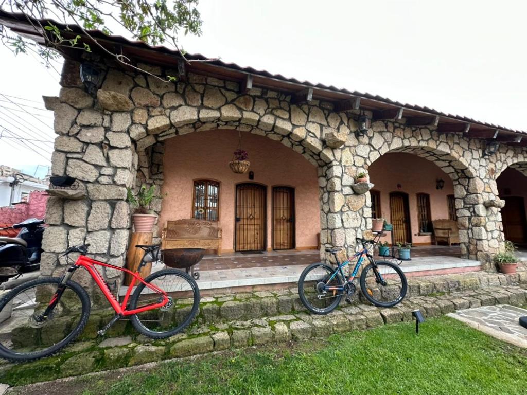 dos bicicletas estacionadas frente a una casa de piedra en Cozy Room, en Tecpán Guatemala