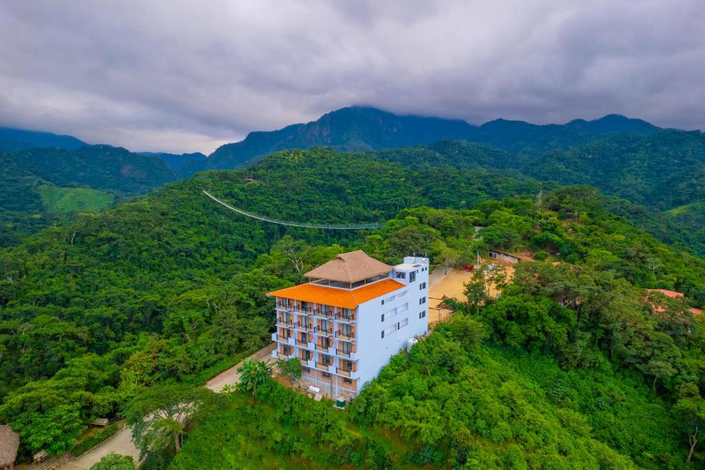 an aerial view of a building on a hill with trees at River Park Hotel in Puerto Vallarta