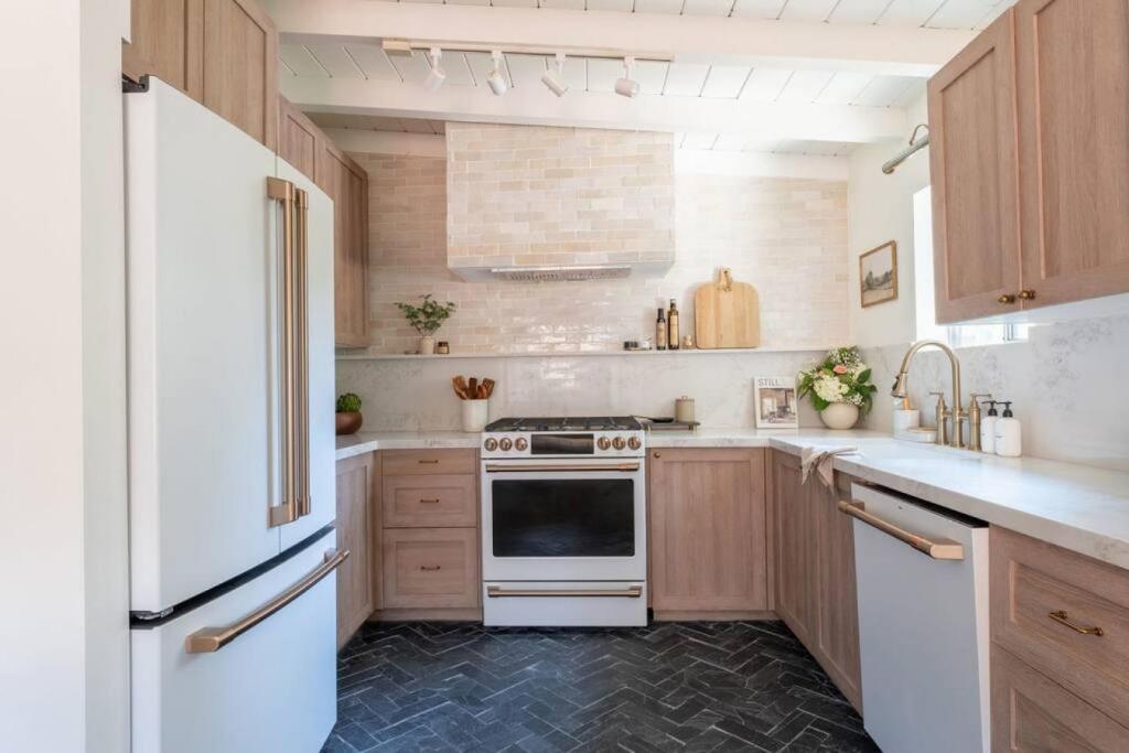 eine Küche mit weißen Geräten und Holzschränken in der Unterkunft Lily Rock Cottage by Roav Retreats in Idyllwild