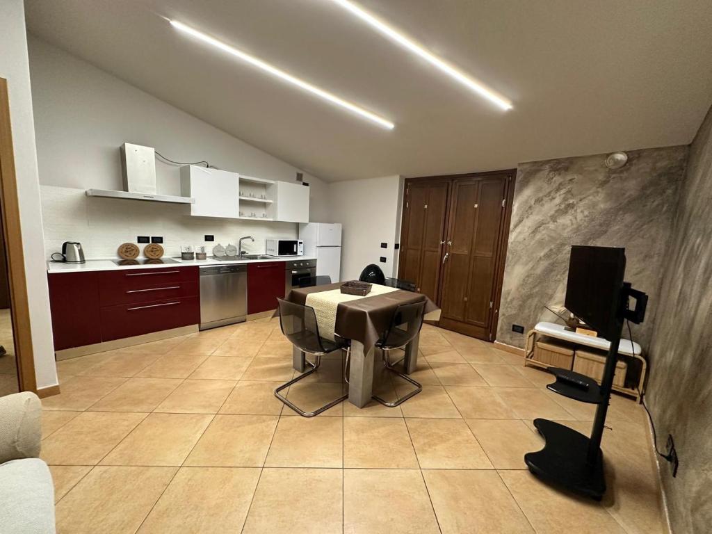 een woonkamer met een tafel en een keuken bij Alvina's House in Aosta