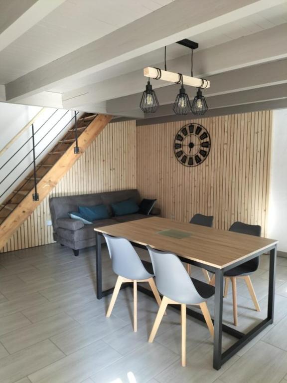 une table à manger et des chaises dans un salon dans l'établissement Maison de campagne, à Montusclat